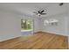 Bright bedroom features wood-look flooring, a ceiling fan, a sliding glass door, and a window at 2822 Brookline Ave, New Smyrna Beach, FL 32168