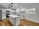 Modern white kitchen with stainless steel appliances, a central island, and sleek countertops at 2822 Brookline Ave, New Smyrna Beach, FL 32168