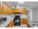 Kitchen with wood cabinets, black appliances and modern countertops, with a laundry room nearby at 2917 Crockett Pt, Sanford, FL 32773