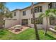 Picturesque backyard featuring a stone table set, lush lawn, and tropical palms surrounding the property at 2961 Oceans Trce, Daytona Beach Shores, FL 32118