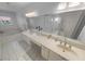 A clean, bright bathroom with a double vanity, tub, and shower in a neutral color palette at 2961 Oceans Trce, Daytona Beach Shores, FL 32118