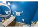 Stylish half-bathroom featuring blue walls, a vanity with a marble countertop, and white fixtures at 2961 Oceans Trce, Daytona Beach Shores, FL 32118