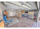 Spacious garage featuring tile floors, a seating area, a dining set, and a grill, perfect for entertaining at 2961 Oceans Trce, Daytona Beach Shores, FL 32118