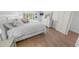 Cozy main bedroom featuring wood floors, comfortable bedding, and natural light from the nearby windows at 2961 Oceans Trce, Daytona Beach Shores, FL 32118