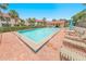 Inviting community pool with brick patio, lounge chairs, and lush tropical landscaping, offering a relaxing retreat at 2961 Oceans Trce, Daytona Beach Shores, FL 32118