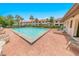 Inviting community pool with red brick patio, lounge chairs, and lush tropical landscaping, offering a relaxing retreat at 2961 Oceans Trce, Daytona Beach Shores, FL 32118