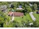 Aerial view of a charming home with well-maintained lawn and mature trees, complemented by a covered carport at 3048 Mango Tree Dr, Edgewater, FL 32141