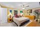 Bright bedroom with a ceiling fan, dresser, and a large window providing plenty of natural light at 3048 Mango Tree Dr, Edgewater, FL 32141