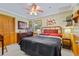 Charming bedroom features wood-paneled walls, a ceiling fan, and a comfortable bed with stylish decor at 3048 Mango Tree Dr, Edgewater, FL 32141