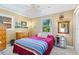 This cozy bedroom features a comfortable bed, ample natural light, and a view of the outdoors at 3048 Mango Tree Dr, Edgewater, FL 32141