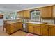 Traditional kitchen with wood cabinets, tiled backsplash, stainless steel appliances, and wood flooring at 3048 Mango Tree Dr, Edgewater, FL 32141