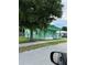 Side view of a charming, vintage green home with a picket-fenced porch and mature landscaping at 306 Sheldon St, New Smyrna Beach, FL 32168