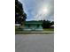 Charming one-story home featuring a porch, green exterior, and well-maintained yard at 306 Sheldon St, New Smyrna Beach, FL 32168