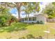 Expansive backyard featuring lush greenery and mature trees with a screened in lanai providing outdoor living at 3120 Mango Tree Dr, Edgewater, FL 32141