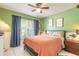 Bright bedroom with a ceiling fan, plush bedding, and natural light from a large window at 3120 Mango Tree Dr, Edgewater, FL 32141