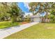 Inviting single-story home featuring a manicured lawn and lovely shade trees providing curb appeal at 3120 Mango Tree Dr, Edgewater, FL 32141