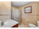 Bright bathroom featuring tiled walls, a shower with patterned curtain, and a window at 3222 Juniper Dr, Edgewater, FL 32141