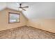 Attic bedroom featuring a ceiling fan, window, and carpet flooring at 3222 Juniper Dr, Edgewater, FL 32141
