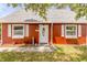 Front exterior of the home featuring a front door, windows, and flower pots at 3222 Juniper Dr, Edgewater, FL 32141