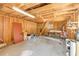 Interior view of a cluttered wood-paneled garage with concrete floors and ladder leading to an upper level at 3222 Juniper Dr, Edgewater, FL 32141