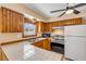 Charming kitchen boasting stainless appliances, wooden cabinets, tile counters, and a bright window above the sink at 3222 Juniper Dr, Edgewater, FL 32141