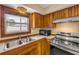 Updated kitchen featuring wood cabinets, stainless appliances, tile countertops, and a window over a stainless sink at 3222 Juniper Dr, Edgewater, FL 32141