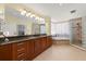 Bathroom boasts double vanity with granite countertop, large mirror, and glass walk-in shower at 3245 S Atlantic Ave # 208, Daytona Beach, FL 32118