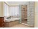The bathroom includes a soaking tub, glass enclosed shower, and tiled flooring at 3245 S Atlantic Ave # 208, Daytona Beach, FL 32118