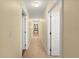 Hallway view featuring tiled flooring, neutral paint, and access to rooms at 3245 S Atlantic Ave # 208, Daytona Beach, FL 32118