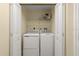 Laundry room featuring a washer and dryer set with overhead storage at 3245 S Atlantic Ave # 208, Daytona Beach, FL 32118