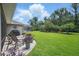 Spacious backyard with a view of the pool, mature trees, and a manicured lawn at 3378 Leonardo Ln, New Smyrna Beach, FL 32168