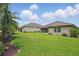 Beautifully landscaped backyard with green lawn, mature trees, and a well-maintained patio area at 3378 Leonardo Ln, New Smyrna Beach, FL 32168