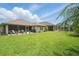 Expansive backyard featuring a pool, lush lawn, and a screened-in patio for outdoor enjoyment at 3378 Leonardo Ln, New Smyrna Beach, FL 32168