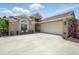 Inviting home exterior with a two-car garage, a bench, and tasteful landscaping at 3378 Leonardo Ln, New Smyrna Beach, FL 32168