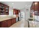 Well-lit kitchen with granite countertops, cherry cabinets, and stainless steel appliances at 3378 Leonardo Ln, New Smyrna Beach, FL 32168
