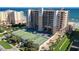 The building has multiple balconies with tennis courts, palm trees, and lush landscaping and ocean view at 4139 S Atlantic Ave # A302, New Smyrna Beach, FL 32169