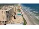 Panoramic aerial shot showcases a pool along the beachline with a high rise condo building, and ocean views at 4139 S Atlantic Ave # A302, New Smyrna Beach, FL 32169