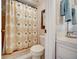 Cozy bathroom with palm tree themed shower curtain and neutral tile at 4139 S Atlantic Ave # A302, New Smyrna Beach, FL 32169