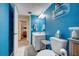 Blue bathroom features a modern sink, toilet, and decorative elements at 4139 S Atlantic Ave # A302, New Smyrna Beach, FL 32169