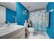 The blue bathroom has a sink, toilet, and shower with a themed shower curtain and decorative features at 4139 S Atlantic Ave # A302, New Smyrna Beach, FL 32169