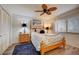 Bright bedroom featuring a ceiling fan, a bed, and a window with blind for a light, airy, and comfortable space at 4139 S Atlantic Ave # A302, New Smyrna Beach, FL 32169