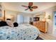 The bright bedroom featuring a mirror, a ceiling fan, a bed, and a window with blinds at 4139 S Atlantic Ave # A302, New Smyrna Beach, FL 32169