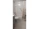 Bathroom with tub-shower combo, grab bar, shower curtain, gray vanity and white tiled floor at 4175 S Atlantic Ave # 2280, New Smyrna Beach, FL 32169