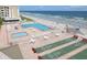 Aerial view of a beachfront pool and amenity deck providing stunning ocean views with shuffleboard courts and lounge seating at 4175 S Atlantic Ave # 2280, New Smyrna Beach, FL 32169
