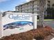 Castle Reef Condominiums sign with landscaped bushes and a palm tree near the street at 4175 S Atlantic Ave # 2280, New Smyrna Beach, FL 32169