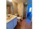 Well-lit bathroom features a single vanity, toilet, storage, and shower with curtain at 421 S Atlantic Ave # 407, New Smyrna Beach, FL 32169