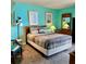 Bright bedroom features attractive wall art and color scheme plus comfortable bedding at 421 S Atlantic Ave # 407, New Smyrna Beach, FL 32169