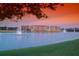 Beautiful waterfront community with fountains and lush green lawn against a colorful sunset sky at 424 Luna Bella Ln # 316, New Smyrna Beach, FL 32168