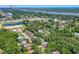 Expansive aerial view of a residential area with lush greenery, a nearby pond, and distant views of the ocean at 428 Perdita Ave, Edgewater, FL 32132