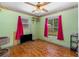 Bright bedroom featuring hardwood floors, two windows, and pink curtains at 428 Perdita Ave, Edgewater, FL 32132